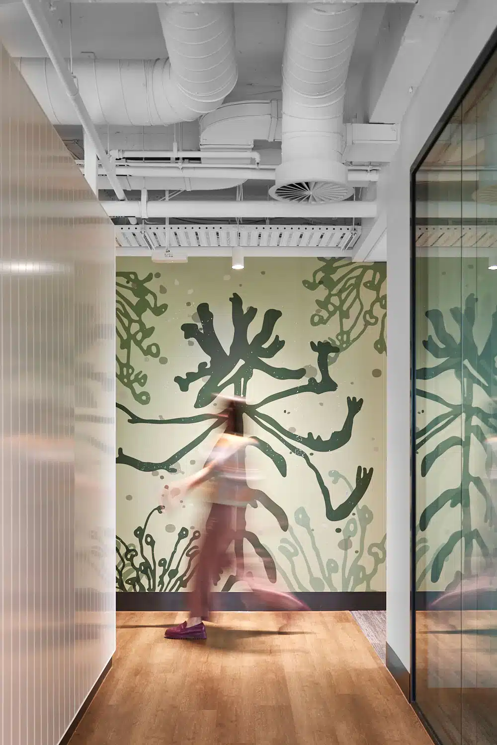 Jason Wing mural in office with someone walking past