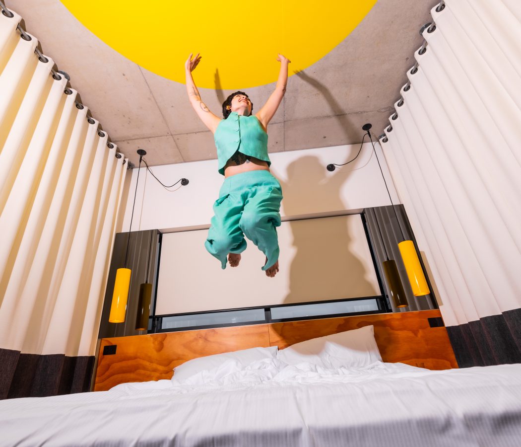 Atura Oran Park interior guest room girl jumping on bed
